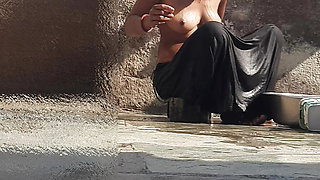 Indian sister-in-law is bathing in the open courtyard of the house, putting a finger in her burrow and rubbing the body, sister-in-law is washing the bathroom.