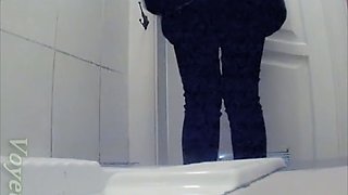 Pale skin white chick in black pants filmed from behind in the toilet
