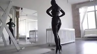 Hooded rubber woman in latex catsuit and ballet boots