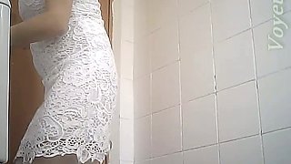Fine curvaceous blonde lady in white dress filmed in the toilet room