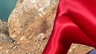 Shiny lycra red pantyhose and black microdress on the mountain