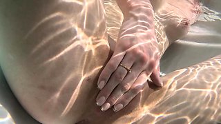 An amateur girl named Mary Moon caresses her peaches on the beach.