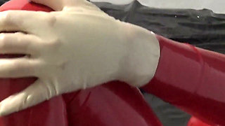 Photoshooting in Red Latex Catsuit with Latex Mask and Transparent Face.