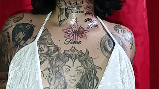 Tattooed Latin woman, black heels plays modeling